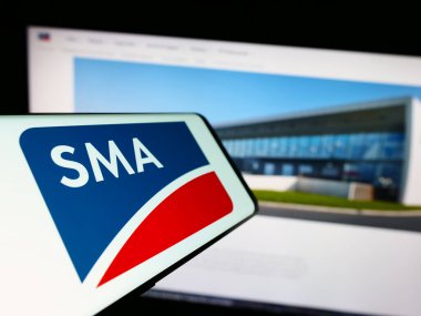 Stuttgart, Almanya - 08-21-2023: Alman firması SMA Solar Technology AG 'nin logosuna sahip akıllı telefon iş sitesinin önünde ekranda. Telefon ekranının merkezine odaklan.