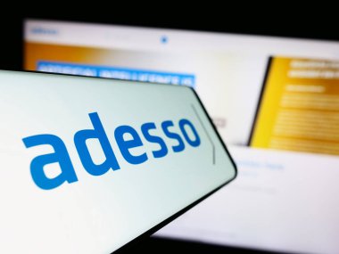 Stuttgart, Almanya - 08-21-2023: Alman danışmanlık şirketi Adesso SE 'nin logosuna sahip akıllı telefon iş dünyasının web sitesinin önünde ekranda. Telefon ekranının merkez soluna odaklan.