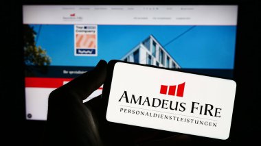 Stuttgart, Almanya - 08-21-2023: Alman işe alım şirketi Amadeus FiRe AG 'nin logosunu taşıyan kişi web sitesi önünde ekranda. Telefon ekranına odaklan.