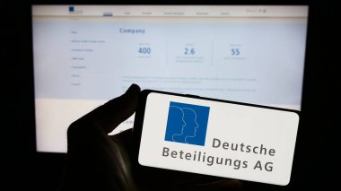 Stuttgart, Almanya - 08-21-2023: Alman firması Deutsche Beteiligungs AG 'nin (DBAG) logosunu elinde tutan kişi web sitesinin önünde ekranda. Telefon ekranına odaklan.