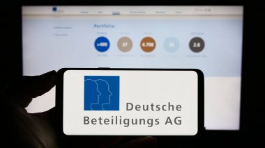 Stuttgart, Almanya - 08-21-2023: Alman Deutsche Beteiligungs AG (DBAG) şirketinin logosunun bulunduğu cep telefonu web sayfası önünde. Telefon ekranına odaklan.