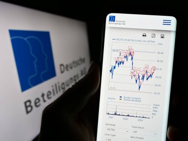 Stuttgart, Almanya - 08-21-2023: Alman firması Deutsche Beteiligungs AG 'nin (DBAG) web sayfası logolu cep telefonu tutan kişi. Telefon ekranının merkezine odaklan.