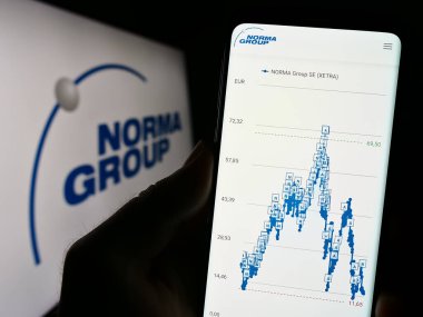 Stuttgart, Almanya - 08-22-2023: Alman imalat şirketi Norma Group SE 'nin web sitesi ile cep telefonu elinde tutan kişi logonun önünde ekranda. Telefon ekranının merkezine odaklan.