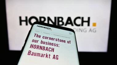 Stuttgart, Almanya - 08-22-2023: Alman firması Hornbach Holding AG Co. KGaA 'nın web sayfalı akıllı telefon, iş logosu önünde ekranda. Telefon ekranının sol üst kısmına odaklan.
