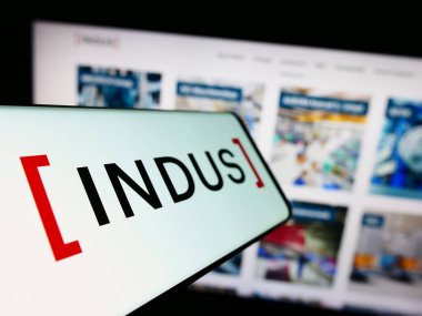 Stuttgart, Almanya - 08-22-2023: Alman yatırım şirketi INDUS Holding AG 'nin logosunun yer aldığı cep telefonu işletme web sitesinin önünde ekranda. Telefon ekranının merkez soluna odaklan.