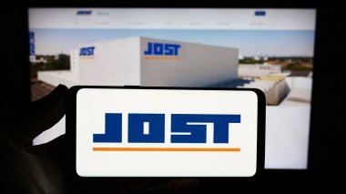 Stuttgart, Almanya - 08-22-2023: Alman otomotiv şirketi Jost Werke SE 'nin logosunu taşıyan kişi web sitesinin önünde ekranda. Telefon ekranına odaklan.
