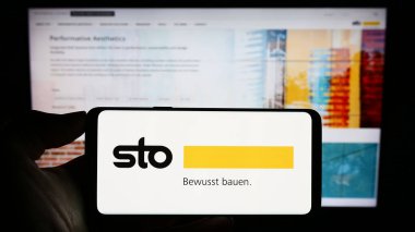 Stuttgart, Almanya - 08-22-2023: Alman inşaat malzemeleri şirketi STO SE Co. KGaA 'nın logosunun bulunduğu cep telefonu web sayfası önünde ekranda. Telefon ekranına odaklan.