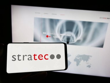 Stuttgart, Almanya - 08-22-2023: Alman tanı firması STRATEC SE 'nin logosunun bulunduğu akıllı telefonu web sitesinin önünde tutan kişi. Telefon ekranına odaklan.