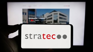 Stuttgart, Almanya - 08-22-2023: Alman tanı şirketi STRATEC SE 'nin logosunun bulunduğu cep telefonu sahibi kişi iş sayfasının önünde ekranda. Telefon ekranına odaklan.