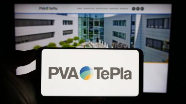Stuttgart, Almanya - 08-22-2023: Alman teknoloji şirketi PVA TePla AG 'nin logosuyla cep telefonu sahibi kişi iş sayfasının önünde ekranda. Telefon ekranına odaklan.