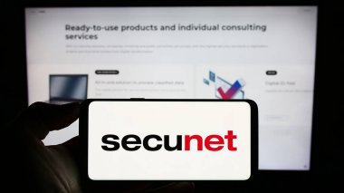 Stuttgart, Almanya - 08-22-2023: İnternet sitesi önünde üzerinde Alman güvenlik ağlarının logosu bulunan akıllı telefon sahibi kişi. Telefon ekranına odaklan.