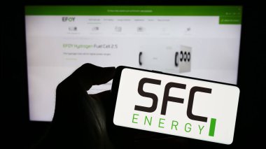 Stuttgart, Almanya - 08-22-2023: Alman firması SFC Energy AG 'nin logosuyla cep telefonu sahibi kişi iş sayfasının önünde ekranda. Telefon ekranına odaklan.