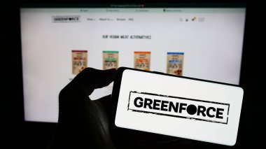 Stuttgart, Almanya - 08-24-2023: Alman firması Greenforce Future Food AG 'nin logosunun bulunduğu cep telefonu sahibi kişi iş sayfasının önünde ekranda. Telefon ekranına odaklan.