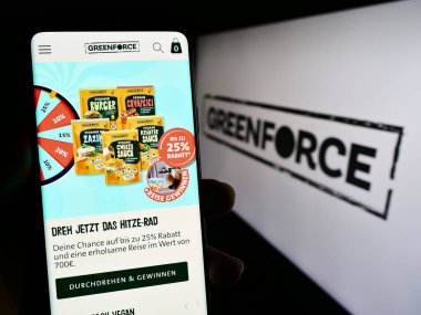 Stuttgart, Almanya - 08-24-2023: Alman firması Greenforce Future Food AG 'nin internet sayfasını elinde tutan kişi logolu ekranda. Telefon ekranının merkezine odaklan.