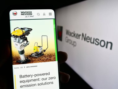 Stuttgart, Almanya - 08-24-2023: Alman makine şirketi Wacker Neuson SE 'nin internet sayfası ile cep telefonu tutan kişi logolu ekranda. Telefon ekranının merkezine odaklan.