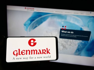 Stuttgart, Almanya - 08-25-2023: Hint Glenmark Pharmaceuticals Limited şirketinin logosuna sahip akıllı telefon sahibi kişi web sitesinin önünde ekranda. Telefon ekranına odaklan.