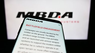 Stuttgart, Germany - 08-25-2023: Mobile phone with website of French missile systems company MBDA SAS on screen in front of business logo. Focus on top-left of phone display. clipart