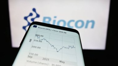 Stuttgart, Almanya - 08-26-2023: Hint biyofarmasötik şirketi Biocon Limited 'in web sitesiyle birlikte cep telefonu logonun önünde ekranda. Telefon ekranının sol üst kısmına odaklan.
