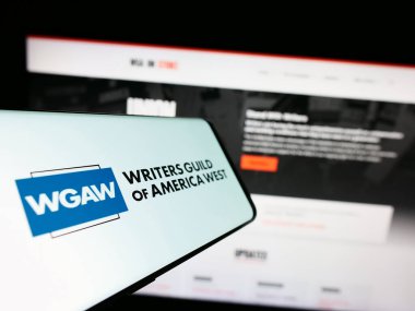 Stuttgart, Almanya - 08-26-2023: Web sitesi önünde ekranda İşçi Sendikası Yazarları Loncası (WGAW) logosu bulunan akıllı telefon. Telefon ekranının merkezine odaklan.