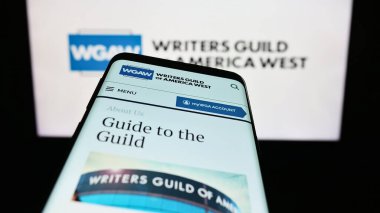 Stuttgart, Almanya - 08-26-2023: İşçi Sendikası Yazarları Loncası (WGAW) web sitesi logonun önünde ekranda. Telefon ekranının sol üst kısmına odaklan.