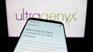 Stuttgart, Almanya - 08-26-2023: ABD 'li Ultragenyx Pharmaceutical Inc.' in web sitesi olan Smartphone iş logosu önünde ekranda. Telefon ekranının sol üst kısmına odaklan.