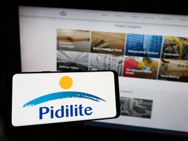 Stuttgart, Almanya - 08-28-2023: Hintli şirket Pidilite Industries Limited 'in logosuyla cep telefonu sahibi kişi iş sayfasının önünde ekranda görülüyor. Telefon ekranına odaklan.
