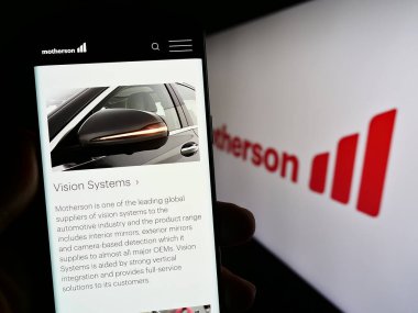 Stuttgart, Almanya - 08-28-2023: Samvardhana Motherson International Ltd. şirketinin web sayfasını elinde tutan kişi logo ile ekranda. Telefon ekranının merkezine odaklan.