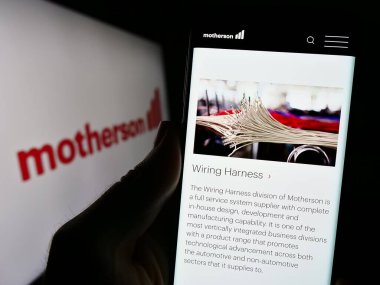 Stuttgart, Almanya - 08-28-2023: Samvardhana Motherson International Ltd. şirketinin web sitesi ile akıllı telefon sahibi kişi logolu ekranda. Telefon ekranının merkezine odaklan.