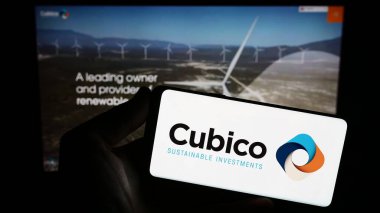Stuttgart, Almanya - 08-28-2023: Cubico Sürdürülebilir Yatırımlar Limited şirketinin logosuna sahip akıllı telefon sahibi kişi web sitesi önünde ekranda. Telefon ekranına odaklan.