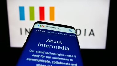 Stuttgart, Almanya - 08-28-2023: ABD 'li şirket Intermedia Cloud Communications' ın web sitesiyle birlikte iş logosu önünde ekranda. Telefon ekranının sol üst kısmına odaklan.