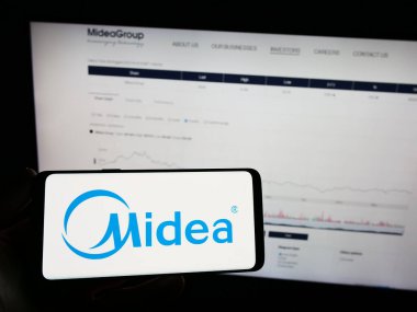 Stuttgart, Almanya - 08-28-2023: Çinli ev aletleri şirketi Midea Group 'un logosunun bulunduğu cep telefonu web sayfası önünde ekranda. Telefon ekranına odaklan.