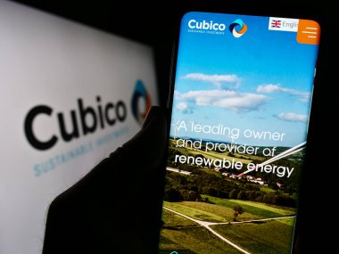 Stuttgart, Almanya - 08-28-2023: Cubico Sürdürülebilir Yatırımlar Limited şirketinin web sitesi ile cep telefonu tutan kişi logolu ekranda görülüyor. Telefon ekranının merkezine odaklan.