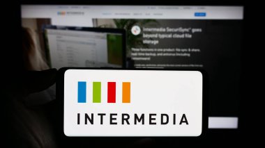 Stuttgart, Almanya - 08-28-2023: Amerikan şirketi Intermedia Cloud Communications 'ın logosunun bulunduğu cep telefonu web sayfası önünde ekranda. Telefon ekranına odaklan.