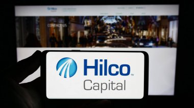 Stuttgart, Almanya - 09-01-2023: İngiliz Hilco Capital Limited şirketinin logosunu elinde tutan kişi web sitesinin önünde ekranda. Telefon ekranına odaklan.
