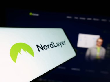 Stuttgart, Almanya - 09-02-2023: Şirket web sitesinin önündeki ekranda ağ erişim servisi NordLayer 'in logosuna sahip akıllı telefon. Telefon ekranının soluna odaklan.