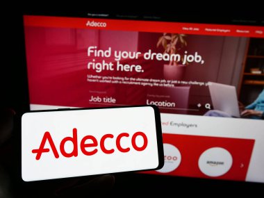 Stuttgart, Almanya - 09-02-2023: Adecco şirketinin logosunu taşıyan kişi web sitesinin önünde ekranda. Telefon ekranına odaklan.