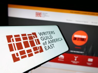 Stuttgart, Almanya - 09-02-2023: Doğu Amerika İşçi Sendikası Yazarları Derneği (WGAE) logosuna sahip akıllı telefon web sitesi önünde ekranda. Telefon ekranının merkez soluna odaklan.