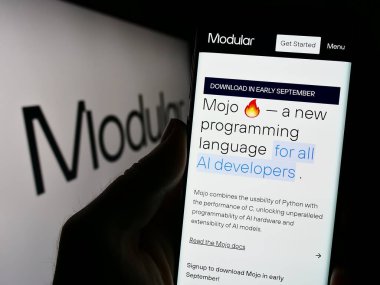 Stuttgart, Almanya - 09-02-2023: Yapay zeka şirketi Modüler Inc. 'nin web sayfası ile ekranda logolu cep telefonu tutan kişi. Telefon ekranının merkezine odaklan.