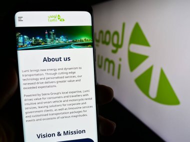 Stuttgart, Almanya - 09-02-2023: Suudi Arabistan araba kiralama şirketi Lumi 'nin web sitesi ile akıllı telefon sahibi kişi logonun önünde ekranda. Telefon ekranının merkezine odaklan.
