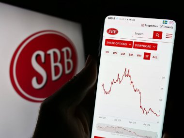 Stuttgart, Almanya - 09-06-2023: Samhallsbyggnadsbolaget i Norden AB 'nin (SBB) web sayfası logonun önünde duran kişi. Telefon ekranının merkezine odaklan.