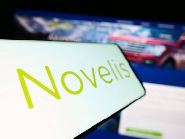 Stuttgart, Almanya - 09-06-2023: Amerikan alüminyum şirketi Novelis Inc. 'in logosuna sahip akıllı telefon, iş dünyasının web sitesinin önünde ekranda. Telefon ekranının soluna odaklan.