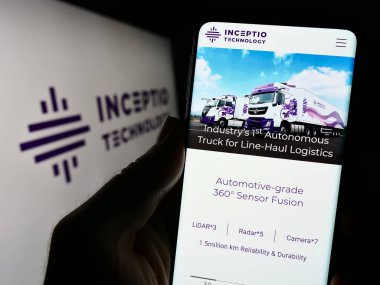 Stuttgart, Almanya - 09-07-2023: Otomatik araç şirketi Inceptio Technology 'nin logolu web sayfası ile cep telefonu tutan kişi. Telefon ekranının merkezine odaklan.