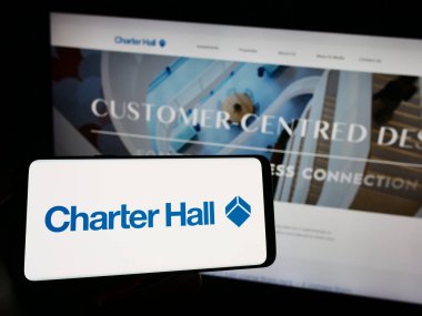 Stuttgart, Almanya - 09-07-2023: Emlak şirketi Charter Hall Group 'un logosuyla cep telefonu sahibi kişi iş sayfasının önünde ekranda. Telefon ekranına odaklan.