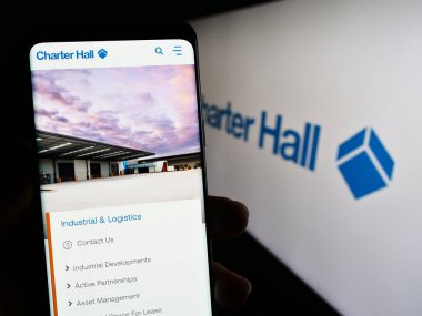 Stuttgart, Almanya - 09-07-2023: Emlak şirketi Charter Hall Group 'un web sayfasını elinde tutan kişi logonun önünde ekranda. Telefon ekranının merkezine odaklan.