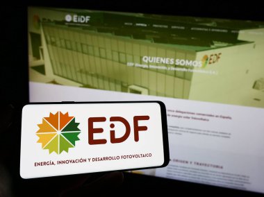 Stuttgart, Almanya - 09-08-2023: İspanyol fotovoltaik şirketi EiDF Solar 'ın logosuna sahip cep telefonu sahibi kişi iş sayfasının önünde ekranda görülüyor. Telefon ekranına odaklan.