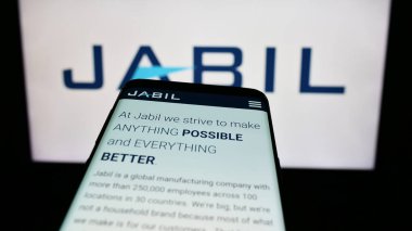 Stuttgart, Almanya - 09-08-2023: ABD 'li elektronik şirketi Jabil Inc.' in web sitesi ile cep telefonu iş logosu önünde ekranda. Telefon ekranının sol üst kısmına odaklan.