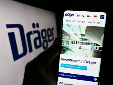 Stuttgart, Almanya - 09-09-2023: Alman firması Draegerwerk AG Co. KGaA 'nın (Drger) internet sayfası ile akıllı telefonu elinde tutan kişi logo ile ekranda. Telefon ekranının merkezine odaklan.