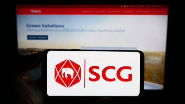 Stuttgart, Almanya - 09-09-2023: İnternet sayfası önünde ekranda The Siam Cement Public Company Limited (SCG) logosunun bulunduğu cep telefonu sahibi kişi. Telefon ekranına odaklan.