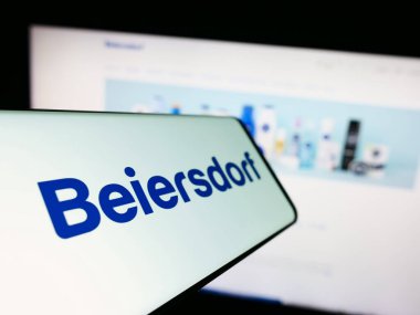 Stuttgart, Almanya - 09-09-2023: Alman tüketici malları şirketi Beiersdorf AG 'nin logosunun yer aldığı cep telefonu iş sitesinin önünde ekranda. Telefon ekranının merkez soluna odaklan.