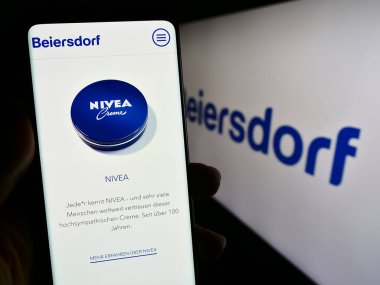 Stuttgart, Almanya - 09-09-2023: Alman tüketici malları şirketi Beiersdorf AG 'nin internet sayfası ile cep telefonu tutan kişi logolu ekranda. Telefon ekranının merkezine odaklan.